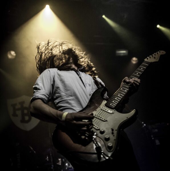 Student Herman Brood Academie op het podium met gitaar