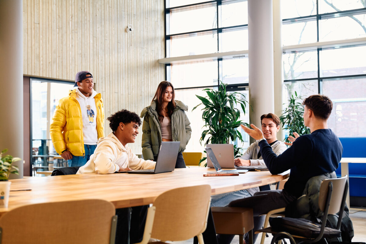 Studenten in gesprek rond een tafel