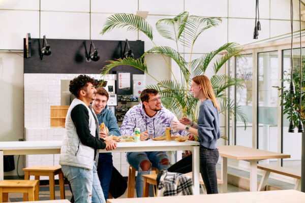 Mbo-studenten Retail en commercie overleggen staand aan een tafel