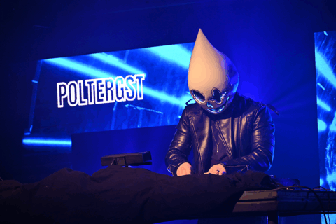 DJ met masker op achter een draaitafel met op de achtergrond de tekst Poltergeist