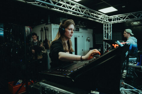 HBA-student Podium- en evenemententechniek achter een bedieningspaneel